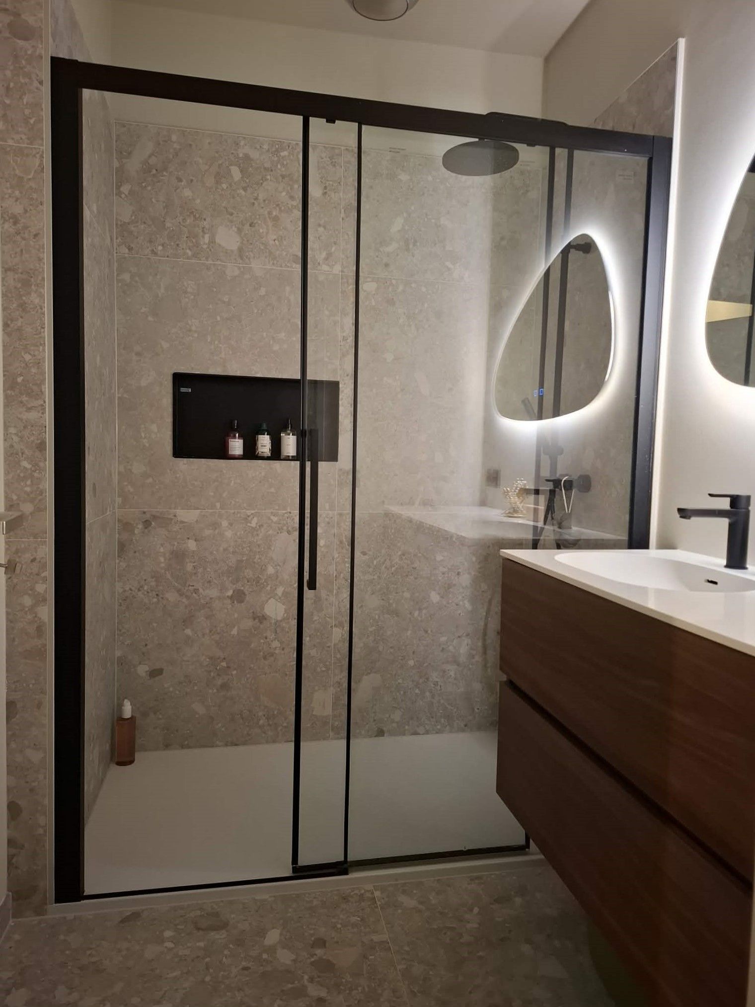 Overzicht van de gerenoveerde badkamer met inloopdouche en badkamermeubel
