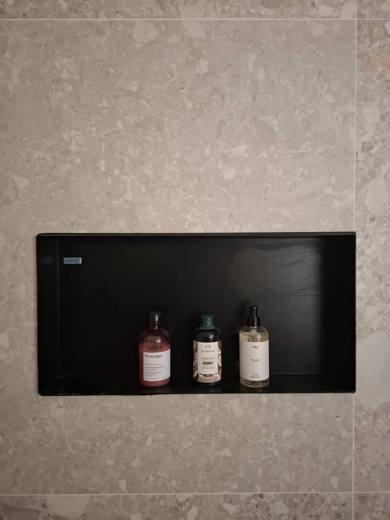 Ingebouwde zwarte nis in de douche voor verzorgingsproducten