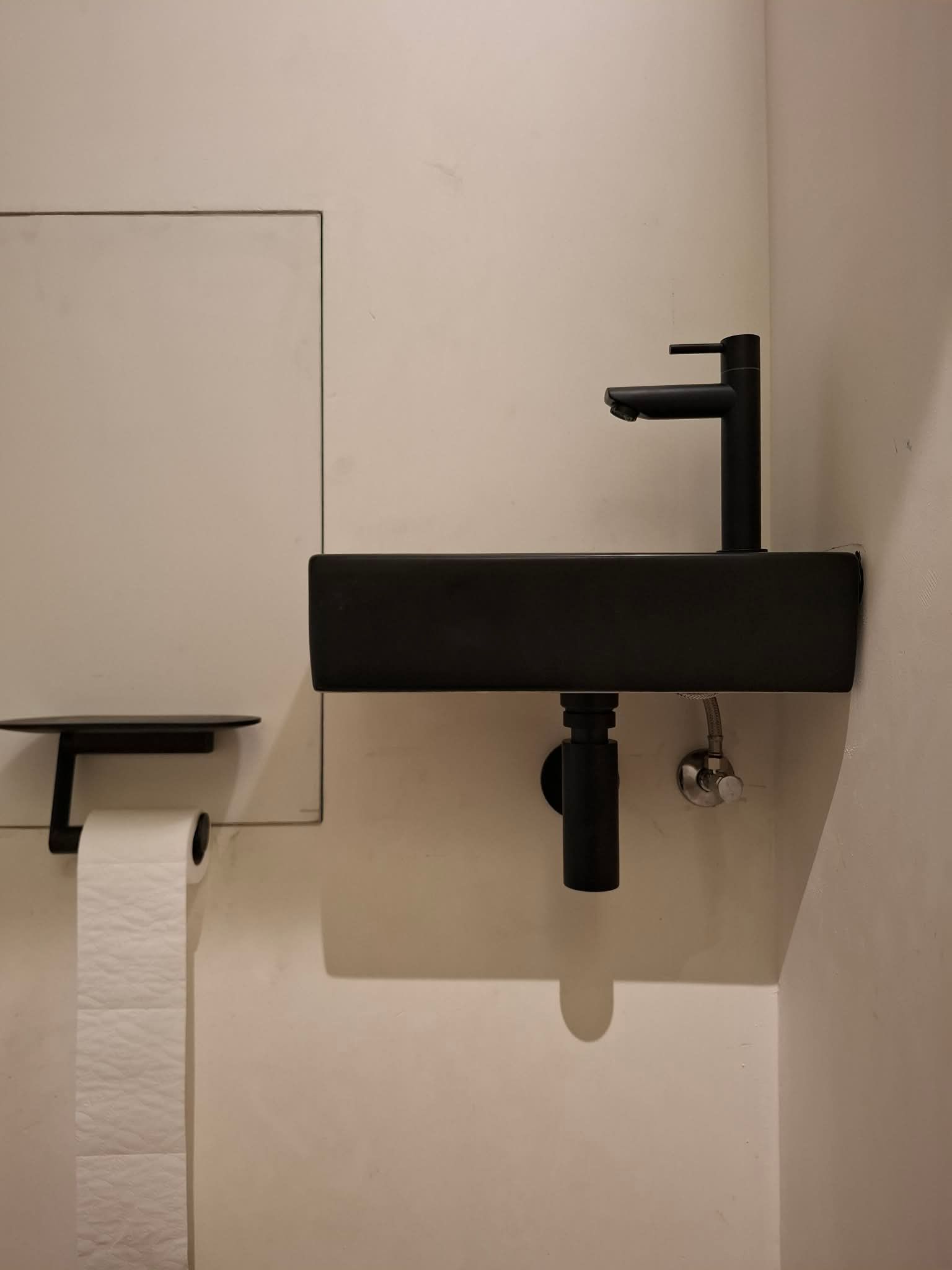 Compact handenwassermeubel met matzwarte kraan in het toilet