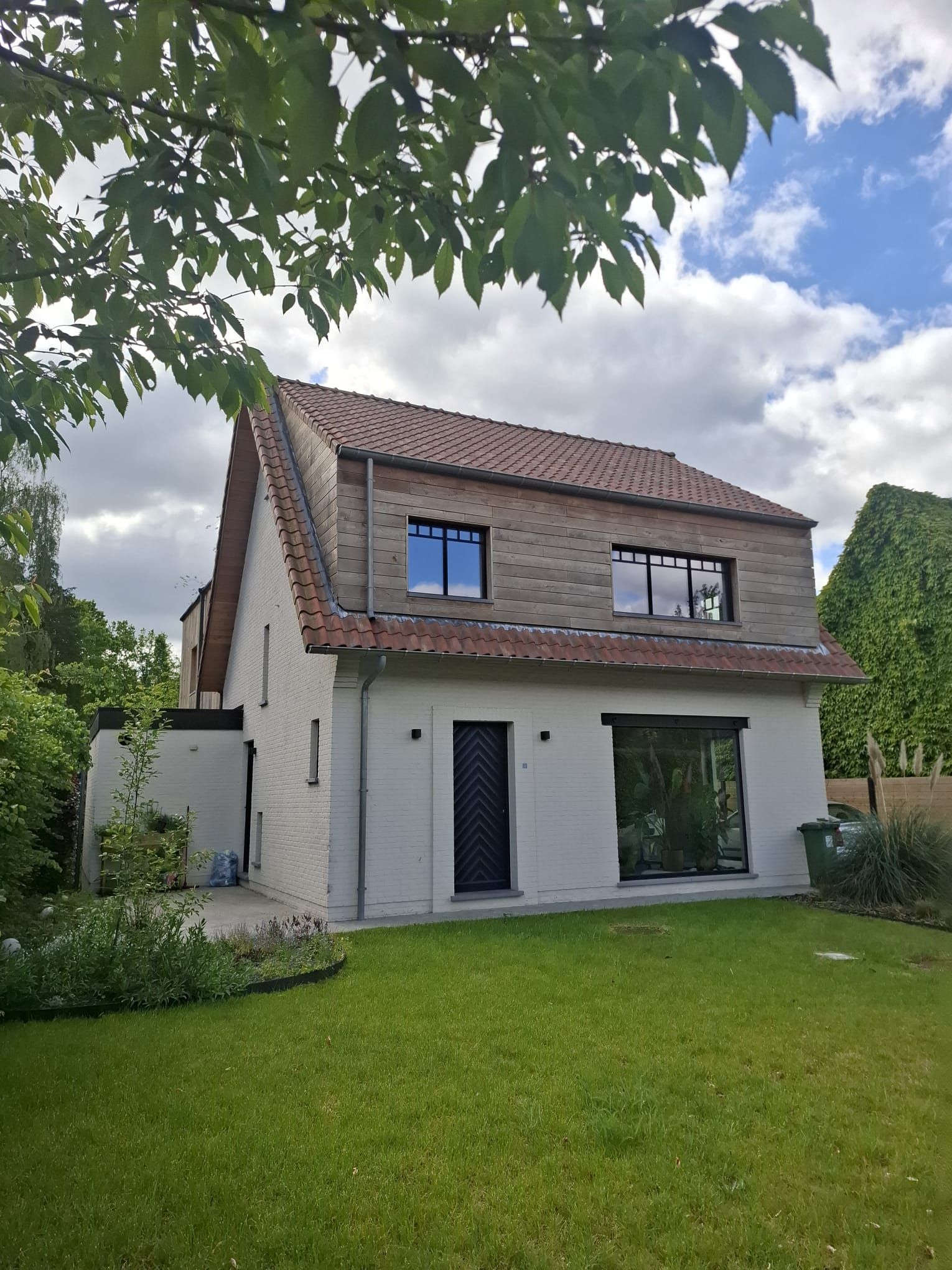 Vooraanzicht van de woning met nieuwe houten gevelbekleding