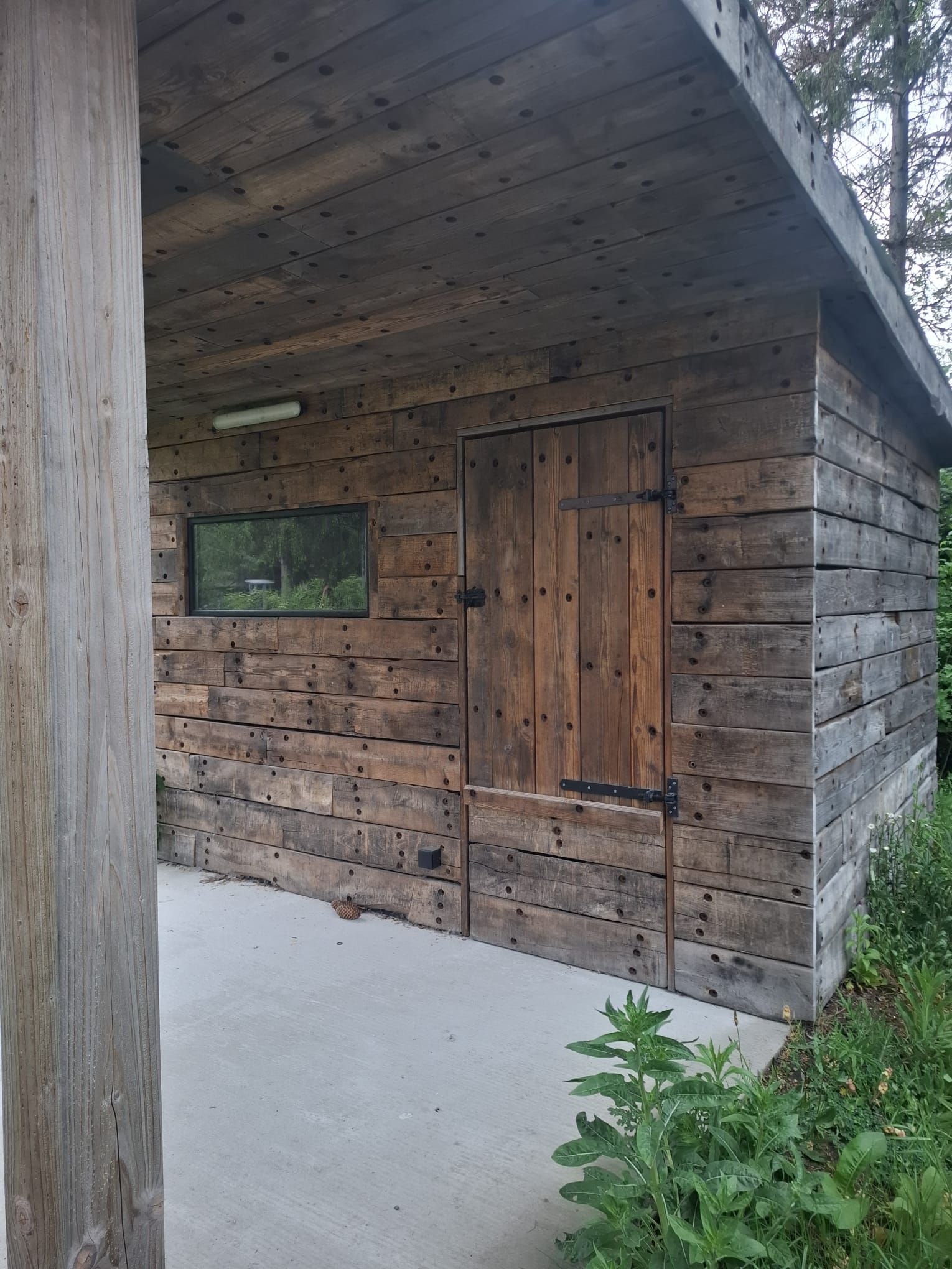 Zijaanzicht van het houten tuinhuis