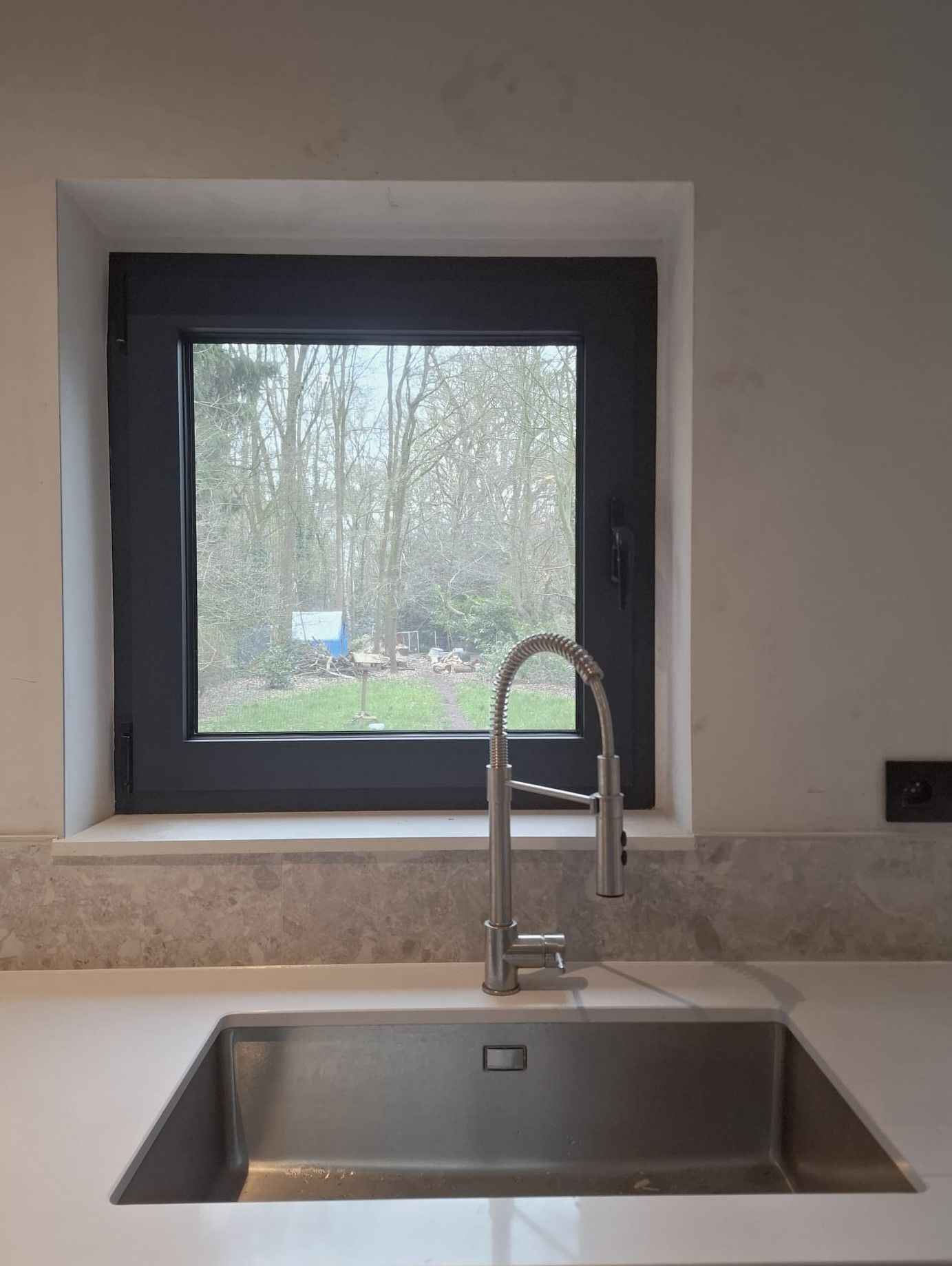Spoelbak en kraan met uitzicht op de tuin